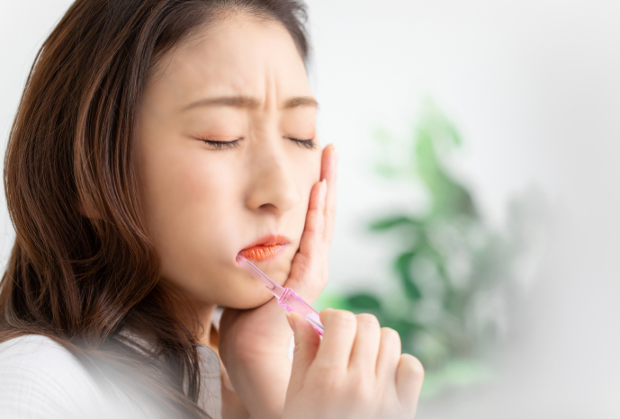 歯が痛くて頬を押さえる女性